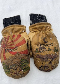 two brown mittens with designs on them