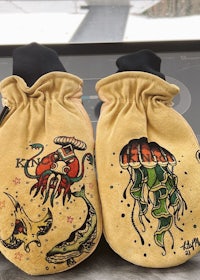 a pair of oven mitts with designs on them