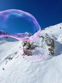 soap bubbles floating in the air over a snow covered mountain